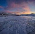 Dramatic sunset over the icy lake in the Arctic tundra. Yamal peninsula.