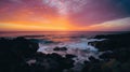 A dramatic sunset over the ocean with orange, pink, and purple hues reflecting on the water Royalty Free Stock Photo