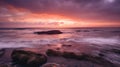 A dramatic sunset over the ocean with orange, pink, and purple hues reflecting on the water Royalty Free Stock Photo