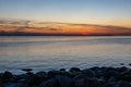 dramatic sunset over sea beach with rocks and stormy water Royalty Free Stock Photo