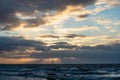 dramatic sunset over sea beach with rocks and stormy water Royalty Free Stock Photo