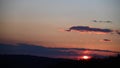 Dramatic sunset over the small clouds and forest trees. 4K time lapse with red purple orange pink dusk cloudy sky. Dramatic landsc