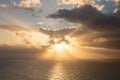 Dramatic sunset rays through a cloudy dark sky over the ocean Royalty Free Stock Photo