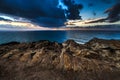 Dramatic sunset rays through a cloudy dark sky over the ocean Royalty Free Stock Photo