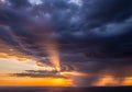 Dramatic sunset scene showcasing a blend of dark storm clouds and vibrant Royalty Free Stock Photo