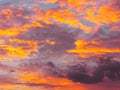 Dramatic sunset sky background with fiery clouds, yellow, orange and pink colors Royalty Free Stock Photo