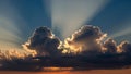 Dramatic sunset sky with crepuscular rays beaming through dark clouds illuminating the horizon with warm orange light Royalty Free Stock Photo