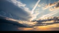 Dramatic sunset sky with dark storm clouds on the left and sun rays breaking through on the right over a flat horizon Royalty Free Stock Photo