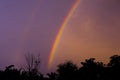 Dramatic sunset sky with double rainbow over countryside landscape Royalty Free Stock Photo