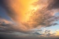 Dramatic sunset sky landscape with puffy clouds lit by orange setting sun and blue heavens