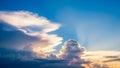 Dramatic sunset sky with luminous golden light rays piercing through dark, voluminous cumulus clouds Royalty Free Stock Photo