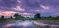 Dramatic sunset sky over old metallic railroad bridge and blurred motion river Royalty Free Stock Photo