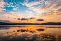 Dramatic sunset sky refecting to flat water surface