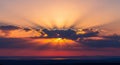 Dramatic sunset sky with sun rays breaking through clouds over ocean Royalty Free Stock Photo