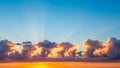 Dramatic sunset sky with vibrant orange and yellow hues illuminating fluffy clouds and sun rays Keywords: sunset Royalty Free Stock Photo