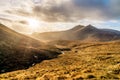 Dramatic sunset with sunrays in beautiful autumn coloured valley with river in Mourne Mountains