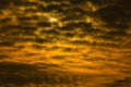Dramatic sunset or sunrise with golden sky and black clouds forming a abstract with sun in the background. Royalty Free Stock Photo
