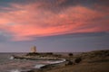 Dramatic Sunset landscape with pink sky and medieval tower, Italy.