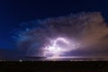 Supercell storm clouds illuminated by lightning strikes Royalty Free Stock Photo