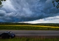 Dramatic thunderstorm cloud over countryside and spring yellow rapeseed fields