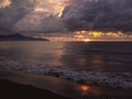 Dramatic Tropical Sunset with Towering Storm Clouds and Golden Rays Over Beach Royalty Free Stock Photo