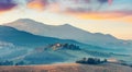 Dramatic Tuscanian view with of fields of wheat and vineyard. Colorful summer sunrise of Italian countryside. Traveling concept ba Royalty Free Stock Photo