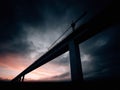 Dramatic view of a bridge under construction against a stormy sky at twilight. Powerful imagery for themes of progress, Royalty Free Stock Photo