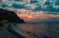 Dramatic view of the last rays of the sun behind the clouds over the beach Royalty Free Stock Photo