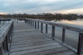 Dramatic view from a wooden lake dock overlooking the stillness on a lake and forest at sunset in Autumn