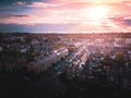 Sun setting with atmospheric effect over traditional British houses and tree lined streets.