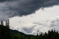 Dramatic weather in the mountains, stormy clouds and tree silhouettes, as a nature background Royalty Free Stock Photo