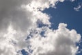 Dramatic white billowy clouds brightly back lit, blue sky.