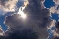 Dramatic white and dark clouds in the blue sky with sun rays breaking through Royalty Free Stock Photo