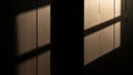 Dramatic window light casting geometric shadows on a warm wooden paneled wall Royalty Free Stock Photo