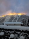 Dramatic winter sunrise over snowy alpine mountains with glowing clouds Royalty Free Stock Photo