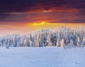 Dramatic winter sunset in snowy mountains.