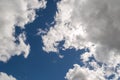 Dramatically illuminated billowy clouds brightly back lit, blue sky.