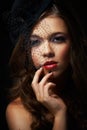 Vintage glam. A dramatically made-up young woman wearing a stylish hat with a netted veil. Royalty Free Stock Photo