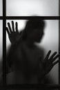 Dramatic silhouette of blurred woman shadow behind window glass Royalty Free Stock Photo
