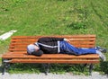 Drank man rests on a bench in park