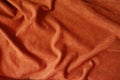 Draped reddish orange artificial suede fabric