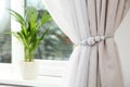 Draped window curtains with tieback in room, space for text