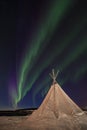 Northern Lights dancing over a traditional sami tent