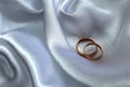 Gold wedding rings lie on satin fabric Royalty Free Stock Photo