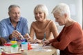 Positive elderly man and women enjoying painting with brush Royalty Free Stock Photo