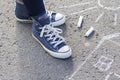 Women`s feet in sneakers are standing on the sidewalk Royalty Free Stock Photo