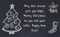 Drawing of christmas tree and handwritten greetings on black chalkboard Royalty Free Stock Photo