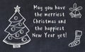 Drawing of christmas tree and handwritten greetings on black chalkboard