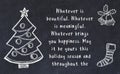 Drawing of christmas tree and handwritten greetings on black chalkboard