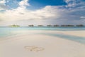 Maldives paradise beach and heart shapes drawing in sand. Moody landscape and sea on sky for holiday vacation background concept